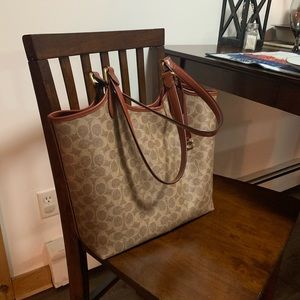 Coach tote brown and beige with maroon color in the inside.